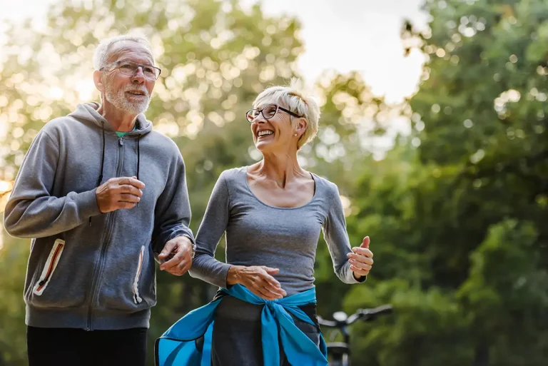 Smiling senior couple jogging in the park