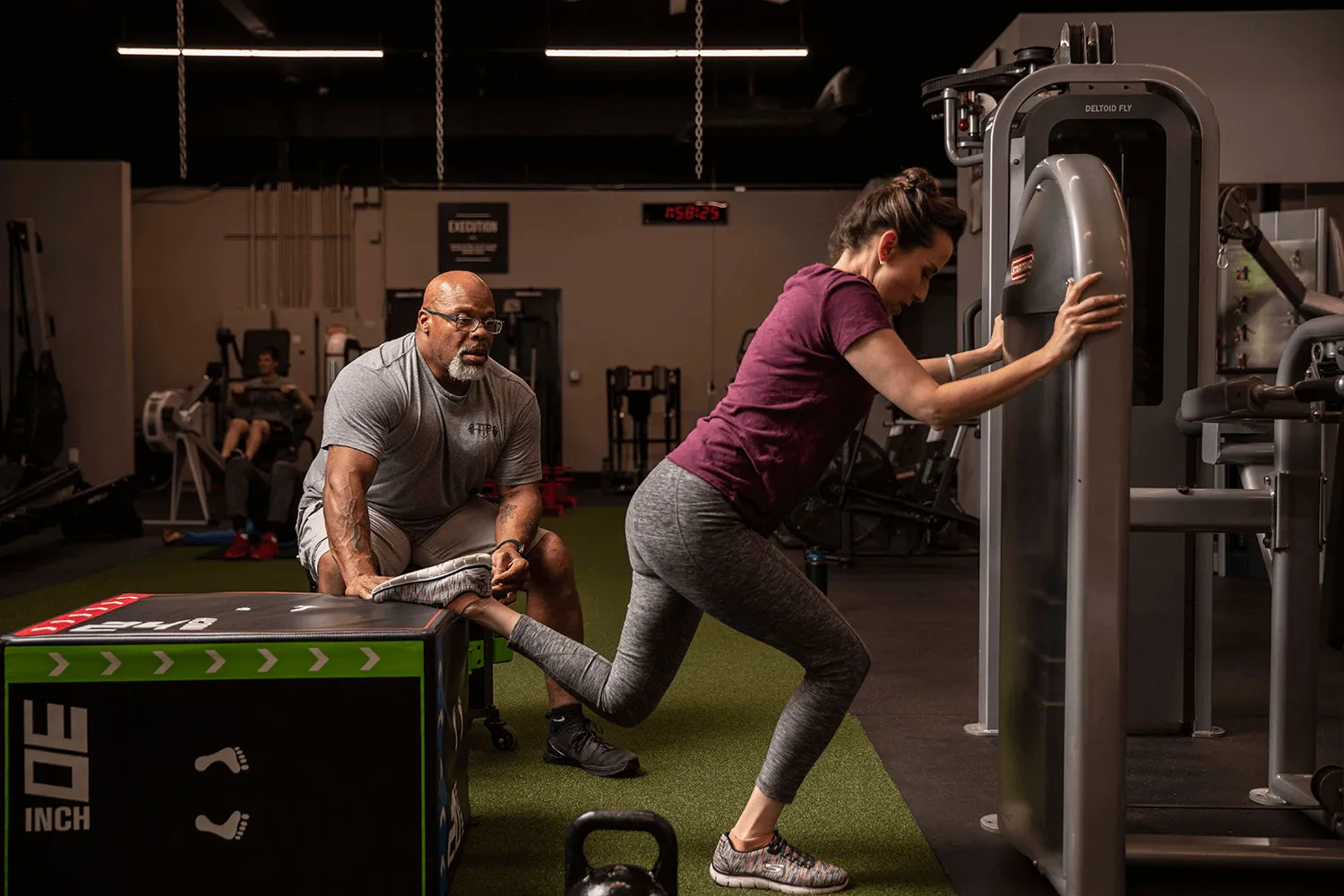 TTP Fitness - Woman performing leg workout with personal trainer Turk