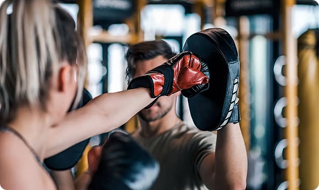 Instructor leading a boxing workout session in the gym